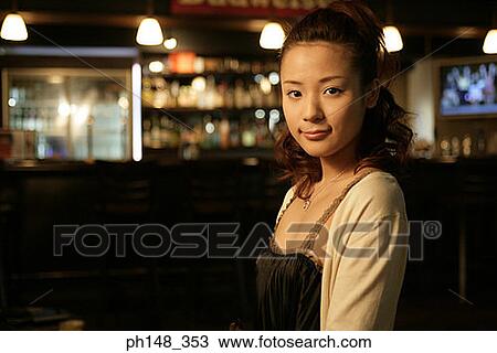 Portrait of a young woman smiling in a nightclub View Large Photo Image Stock Image - Portrait of a young woman smiling in a nightclub. Fotosearch