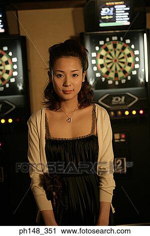 Stock Image - Portrait of a young woman standing in a nightclub. Fotosearch