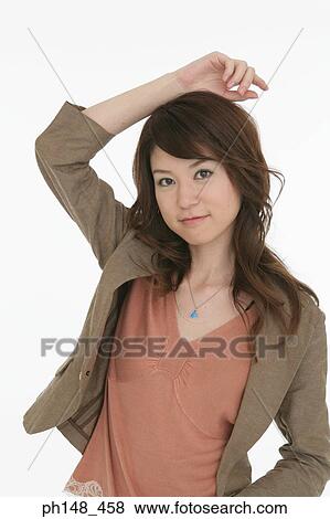 Portrait of a young woman with her hand on her head View Large Photo Image Stock Photo - Portrait of a young woman with her hand on her head. Fotosearch