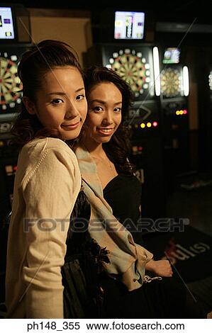 Stock Photography - Portrait of two young women smiling in a nightclub. Fotosearch