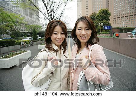 Portrait of two young women standing together and posing View Large Photo Image Picture - Portrait of two young women standing together and posing. Fotosearch