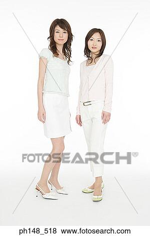 Portrait of two young women standing together View Large Photo Image Stock Photo - Portrait of two young women standing together. Fotosearch