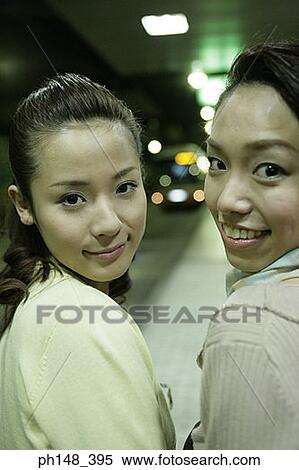 Rear view of two young women smiling together at a subway station View Large Photo Image Stock Photography - Rear view of two young women smiling together at a subway station. Fotosearch