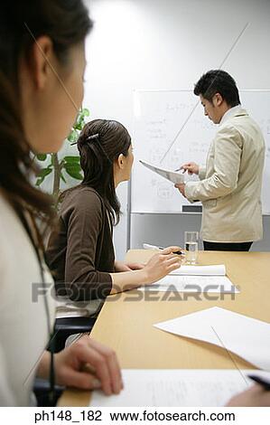 Side profile of a businessman giving a presentation to two businesswomen View Large Photo Image Stock Image - Side profile of a businessman giving a presentation to two businesswomen. Fotosearch