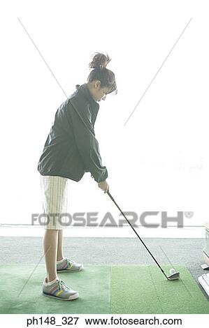 Side profile of a young woman playing golf View Large Photo Image Stock Photo - Side profile of a young woman playing golf. Fotosearch
