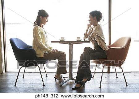 Side profile of two young women sitting in a restaurant View Large Photo Image Stock Image - Side profile of two young women sitting in a restaurant. Fotosearch