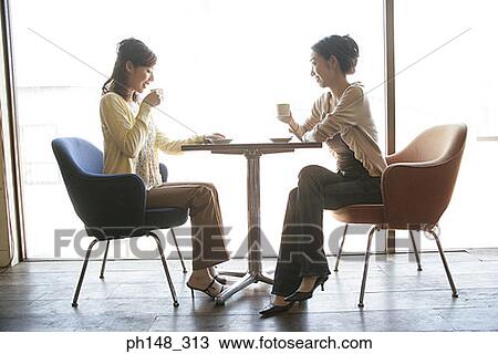 Side profile of two young women sitting in a restaurant View Large Photo Image Stock Image - Side profile of two young women sitting in a restaurant. Fotosearch