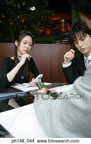 Two businessmen and a businesswoman in a meeting View Large Photo Image Picture - Two businessmen and a businesswoman in a meeting. Fotosearch