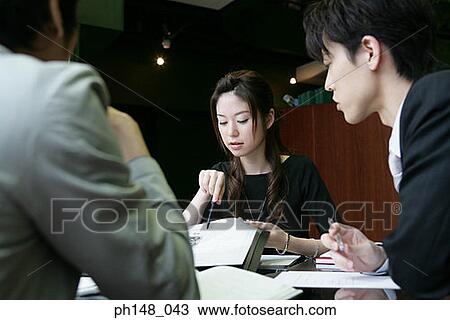 Two businessmen and a businesswoman in a meeting View Large Photo Image Stock Image - Two businessmen and a businesswoman in a meeting. Fotosearch