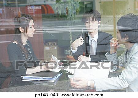 Two businessmen and a businesswoman in a meeting View Large Photo Image Stock Photo - Two businessmen and a businesswoman in a meeting. Fotosearch