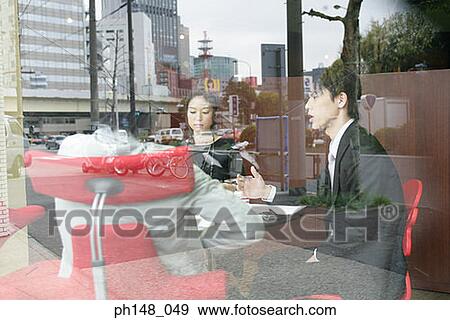 Stock Photo - Two businessmen and a businesswoman in a meeting. Fotosearch