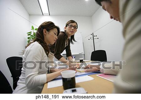 Two businesswomen and a businessman in a meeting View Large Photo Image Stock Image - Two businesswomen and a businessman in a meeting. Fotosearch