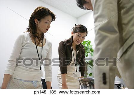 Stock Photography - Two businesswomen and a businessman in a meeting. Fotosearch
