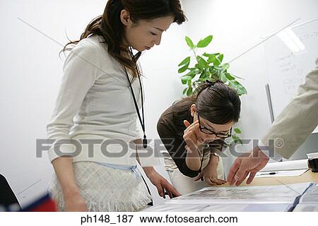 Two businesswomen reading documents View Large Photo Image Stock Photo - Two businesswomen reading documents. Fotosearch