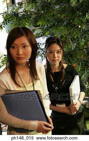 Two businesswomen standing together View Large Photo Image Stock Photography - Two businesswomen standing together. Fotosearch