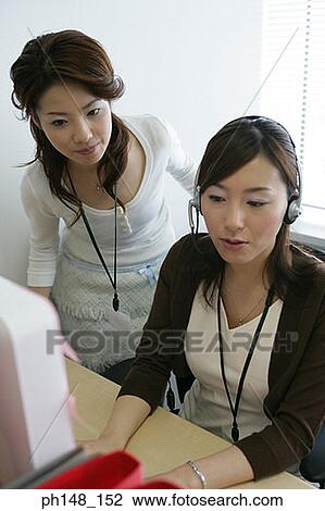 Two businesswomen using a computer in an office View Large Photo Image Stock Image - Two businesswomen using a computer in an office. Fotosearch
