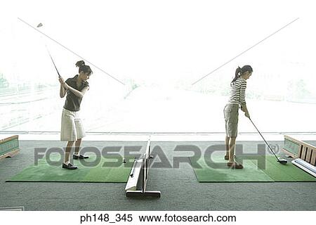 Two young women playing golf View Large Photo Image Stock Photography - Two young women playing golf. Fotosearch