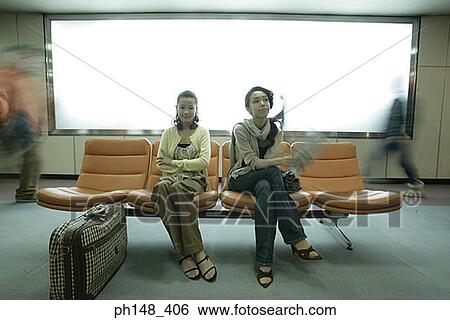 Stock Photograph - Two young women sitting on chairs and waiting. Fotosearch