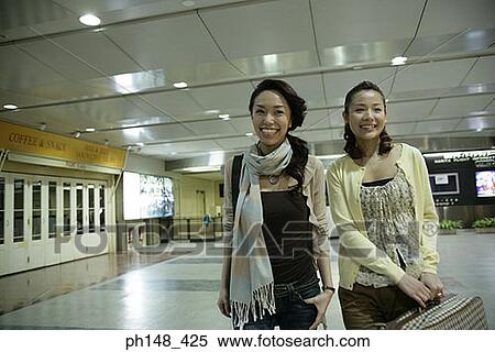 Two young women smiling at a subway station View Large Photo Image Stock Photography - Two young women smiling at a subway station. Fotosearch