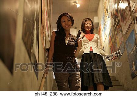 Stock Photo - Two young women walking down stairs. Fotosearch
