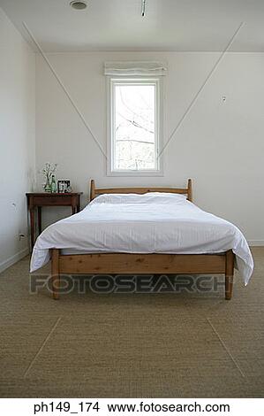Bed with a side table in the bedroom View Large Photo Image Picture - Bed with a side table in the bedroom. Fotosearch