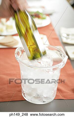 Close-up of a person taking out a wine bottle from an ice bucket View Large Photo Image Stock Photo - Close-up of a person taking out a wine bottle from an ice bucket. Fotosearch