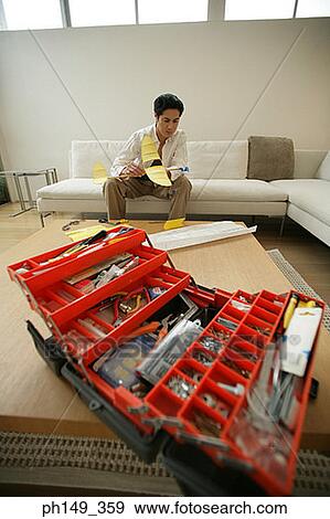 Close-up of a toolbox with a young man holding a paper airplane in the background View Large Photo Image Stock Photo - Close-up of a toolbox with a young man holding a paper airplane in the background. Fotosearch
