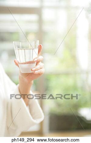 Close-up of a woman's hand holding a glass of water View Large Photo Image Picture - Close-up of a woman's hand holding a glass of water. Fotosearch
