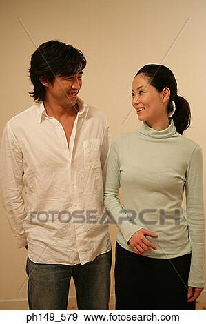 Close-up of a young couple looking at each other and smiling View Large Photo Image Stock Photo - Close-up of a young couple looking at each other and smiling. Fotosearch