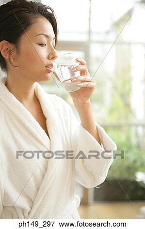 Close-up of a young woman drinking a glass of water View Large Photo Image Stock Photo - Close-up of a young woman drinking a glass of water. Fotosearch