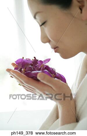 Close-up of a young woman smelling a handful of flowers View Large Photo Image Stock Photo - Close-up of a young woman smelling a handful of flowers. Fotosearch