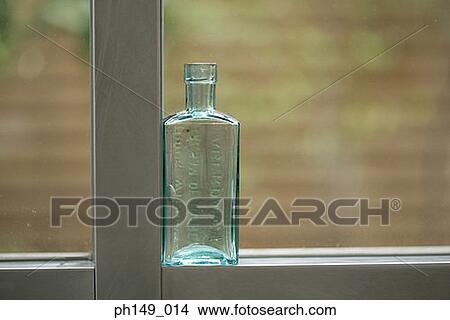 Close-up of an empty bottle on a window sill View Large Photo Image Picture - Close-up of an empty bottle on a window sill. Fotosearch