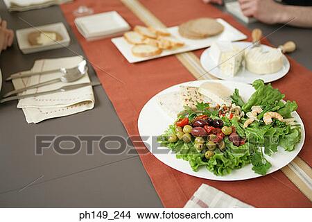 Close-up of fruit salad on the dining table with two people in the background View Large Photo Image Picture - Close-up of fruit salad on the dining table with two people in the background. Fotosearch