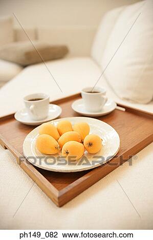 Close-up of loquats in a plate and cups of tea with a saucer on a tray View Large Photo Image Stock Image - Close-up of loquats in a plate and cups of tea with a saucer on a tray. Fotosearch