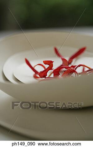 Stock Image - Close-up of petals in a bowl over a plate. Fotosearch
