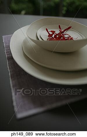 Stock Photo - Close-up of petals in a bowl over a stack of plates. Fotosearch