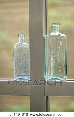 Close-up of two empty bottles on a window sill View Large Photo Image Stock Image - Close-up of two empty bottles on a window sill. Fotosearch