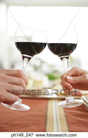 Close-up of two people toasting glasses of red wine View Large Photo Image Stock Photo - Close-up of two people toasting glasses of red wine. Fotosearch