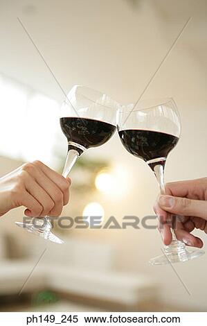 Close-up of two people toasting with glasses View Large Photo Image Stock Photography - Close-up of two people toasting with glasses. Fotosearch
