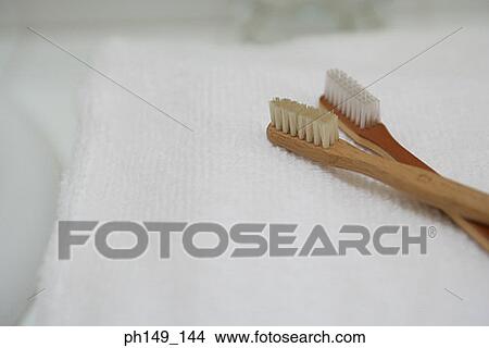 Picture - Close-up of two toothbrushes on a towel. Fotosearch