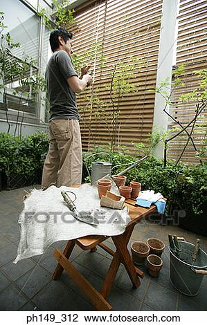 Gardening tools on a stool with a man standing behind it View Large Photo Image Stock Image - Gardening tools on a stool with a man standing behind it. Fotosearch