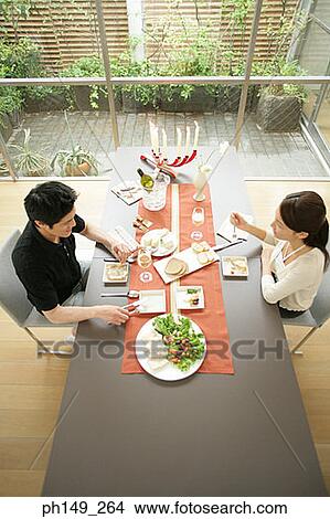 High angle view of a young couple sitting at the dining table View Large Photo Image Picture - High angle view of a young couple sitting at the dining table. Fotosearch