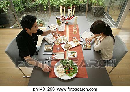 High angle view of a young couple sitting at the dining table View Large Photo Image Stock Image - High angle view of a young couple sitting at the dining table. Fotosearch