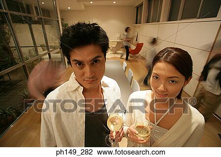 High angle view of a young couple holding glasses of white wine View Large Photo Image Stock Image - High angle view of a young couple holding glasses of white wine. Fotosearch