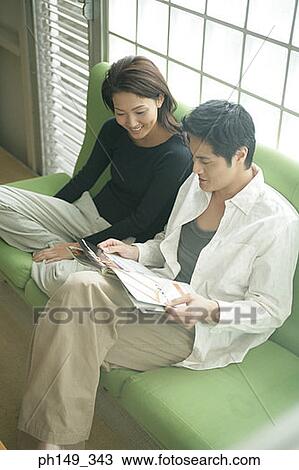 High angle view of a young couple sitting on a couch View Large Photo Image Stock Image - High angle view of a young couple sitting on a couch. Fotosearch