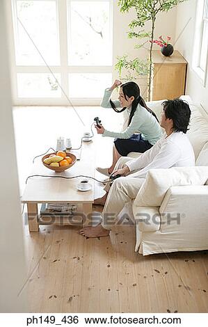 High angle view of a young couple playing video game View Large Photo Image Stock Photograph - High angle view of a young couple playing video game. Fotosearch