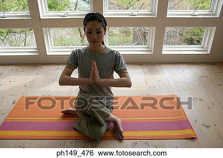 Stock Photograph - High angle view of a young woman practicing yoga. Fotosearch