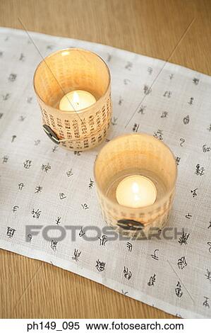 Stock Photography - High angle view of two candles on a place mat. Fotosearch