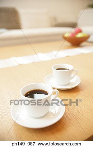High angle view of two cups of black tea with saucers on a table View Large Photo Image Stock Photo - High angle view of two cups of black tea with saucers on a table. Fotosearch