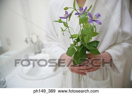 Mid section view of a woman holding flowers View Large Photo Image Stock Photo - Mid section view of a woman holding flowers. Fotosearch